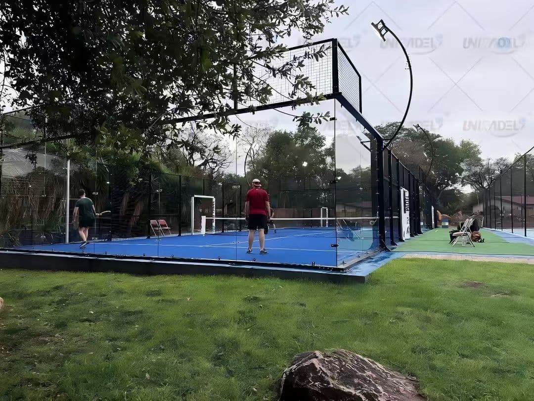 Spieler auf einem verglasten Padelplatz im Freien